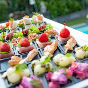 diverse borrelhapjes op zwarte schaal.